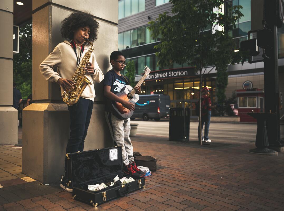 Photograph of musicians collecting money, saving for the cost of recording an album 
